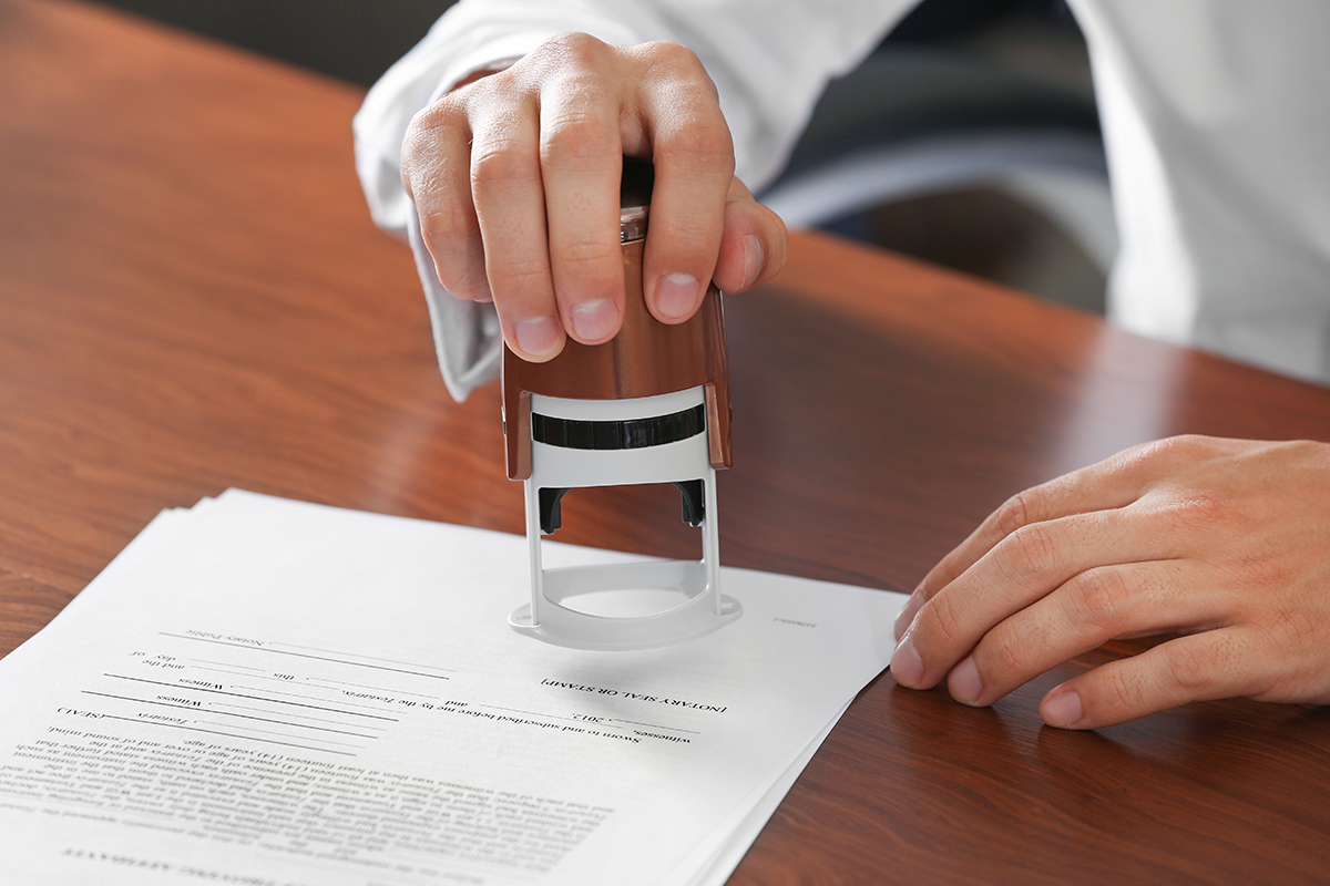Notary public in office stamping document Netzwerk